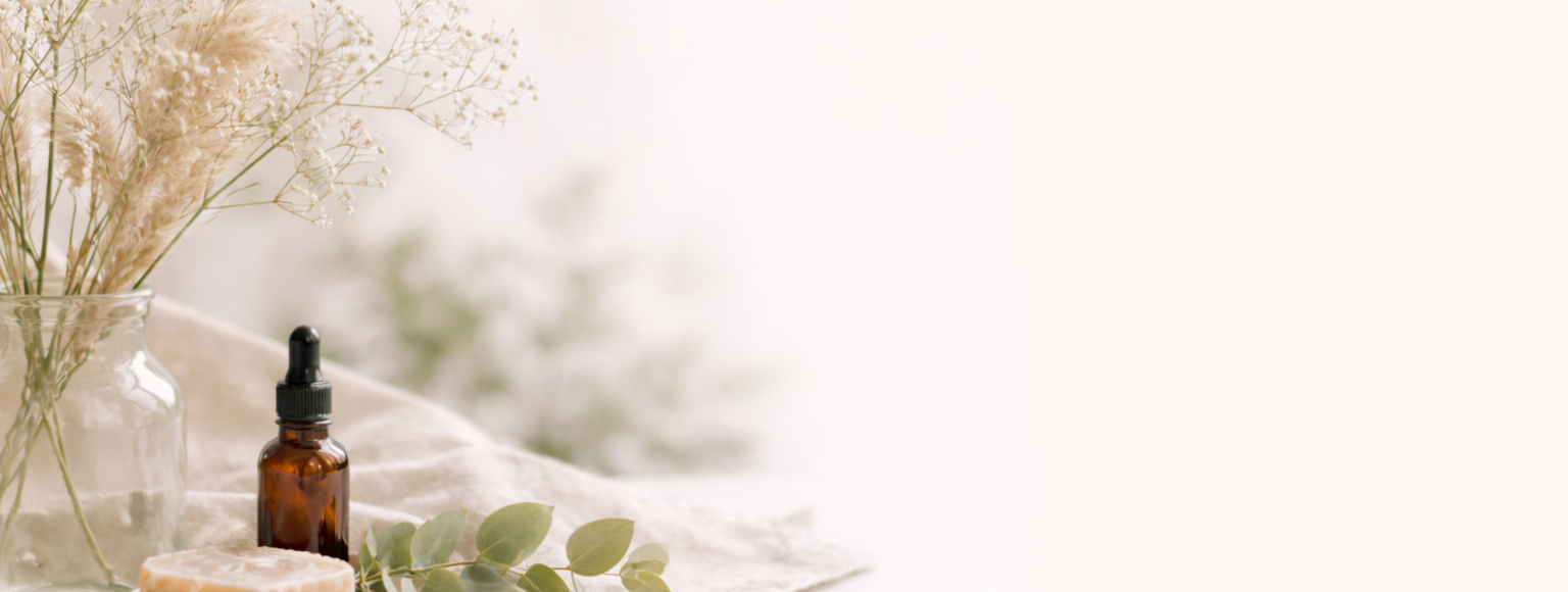Earthlily - A bottle of essential oil, a glass jar with dried flowers, and a bar of soap on a white surface.